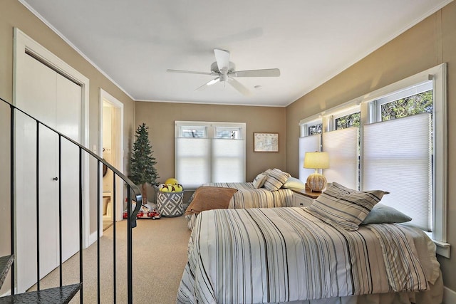 carpeted bedroom featuring crown molding and ceiling fan