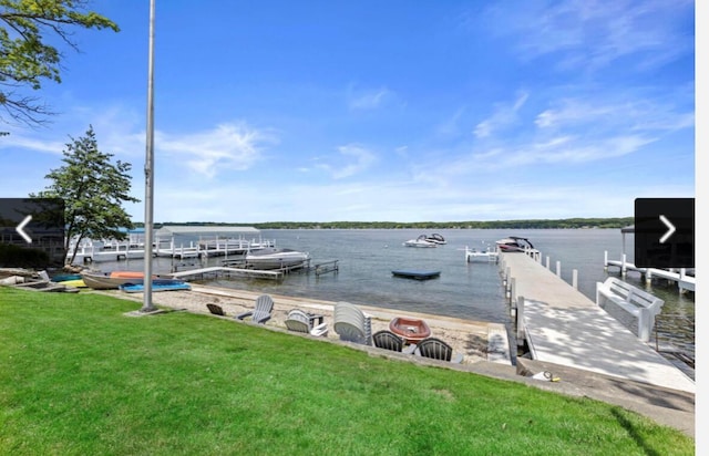 dock area with a lawn and a water view