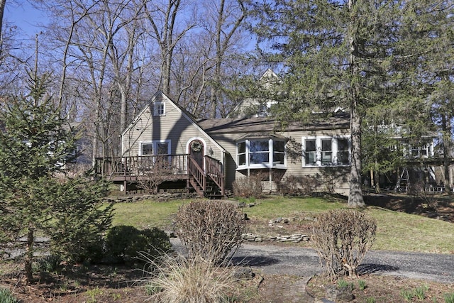 view of front of home with a front yard and a deck