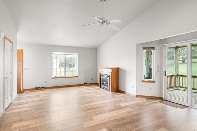 unfurnished living room featuring light wood-type flooring, visible vents, a wealth of natural light, and high vaulted ceiling