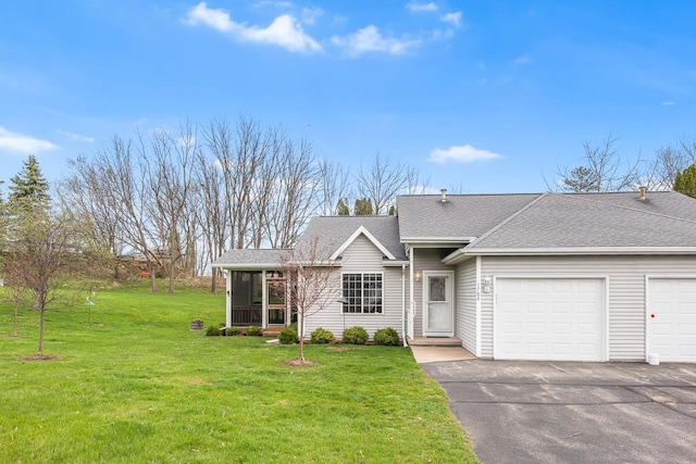 view of front of house with aphalt driveway, a sunroom, roof with shingles, a front yard, and an attached garage