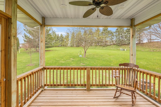 wooden deck with a lawn and a ceiling fan