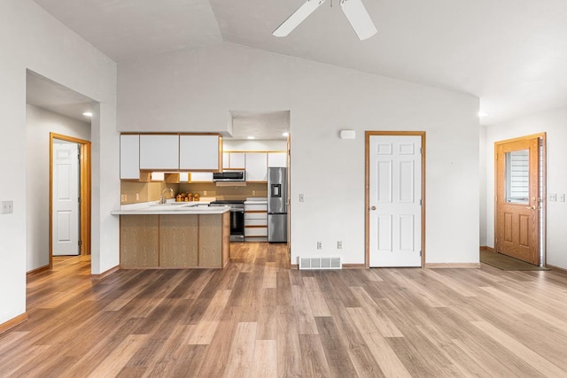 kitchen with stainless steel appliances, light countertops, white cabinets, visible vents, and a peninsula