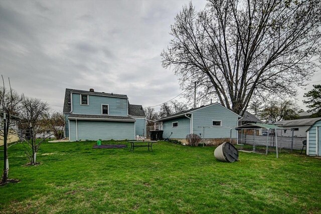 back of house featuring a yard and fence