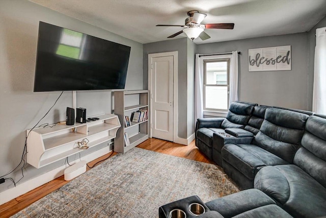 living room with baseboards, ceiling fan, and wood finished floors