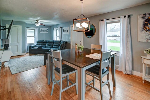 dining space featuring baseboards, light wood-style flooring, and ceiling fan