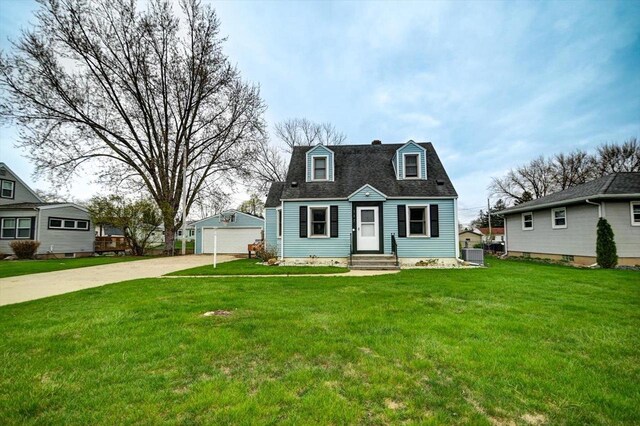 cape cod home featuring a chimney, a front yard, an outbuilding, a garage, and central AC