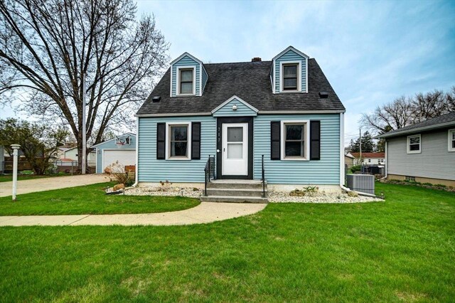 cape cod home featuring roof with shingles, central AC unit, a garage, an outdoor structure, and a front lawn