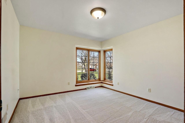 carpeted spare room with baseboards and visible vents