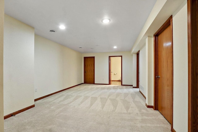 spare room with recessed lighting, light carpet, and baseboards
