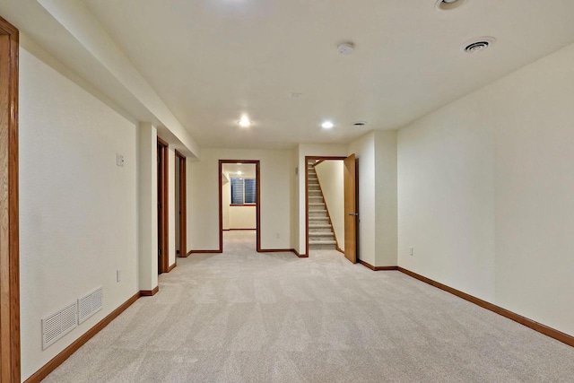 empty room with visible vents, baseboards, stairs, and light carpet