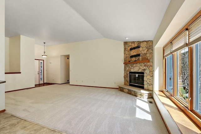 unfurnished living room featuring baseboards, a fireplace, lofted ceiling, and plenty of natural light