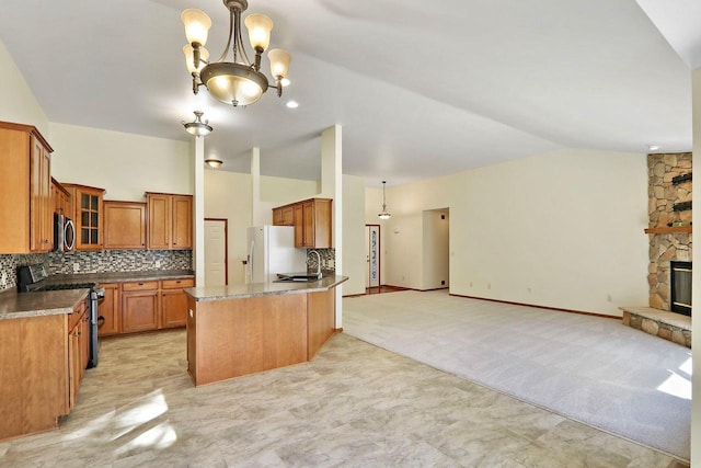 kitchen featuring appliances with stainless steel finishes, open floor plan, brown cabinets, and a sink