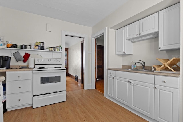 kitchen with a sink, light wood-style floors, white electric range oven, white cabinetry, and light countertops