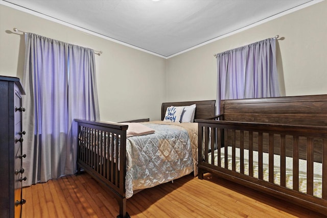 bedroom featuring crown molding and wood-type flooring