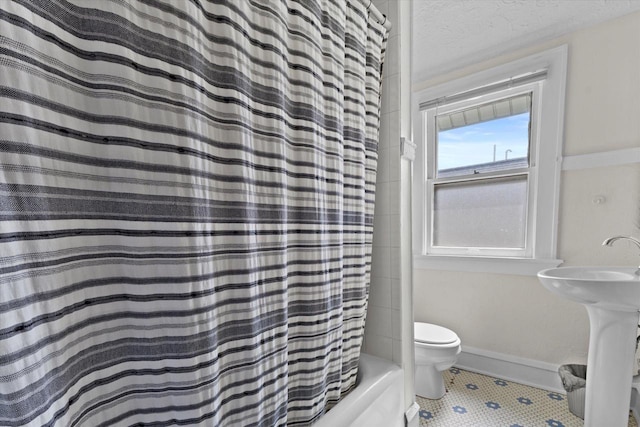 bathroom with toilet, tile patterned flooring, and shower / bath combo with shower curtain