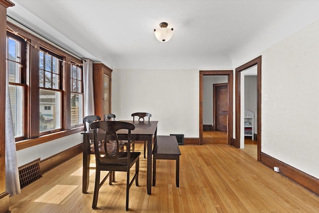 dining room featuring baseboards, visible vents, and light wood-type flooring