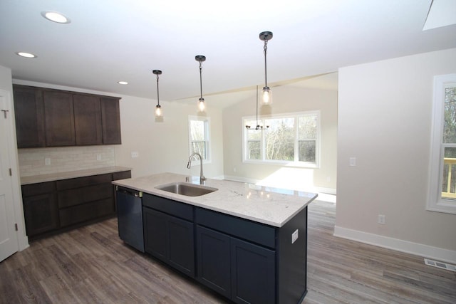 kitchen featuring a sink, decorative backsplash, visible vents, dishwashing machine, and wood finished floors
