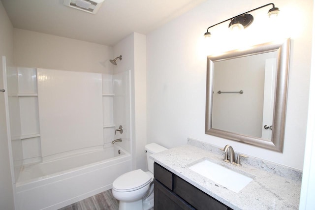 bathroom with washtub / shower combination, visible vents, toilet, wood finished floors, and vanity