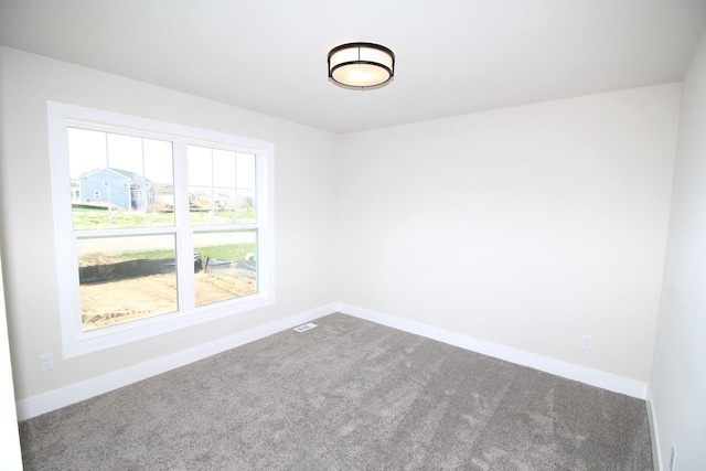 carpeted empty room with visible vents and baseboards