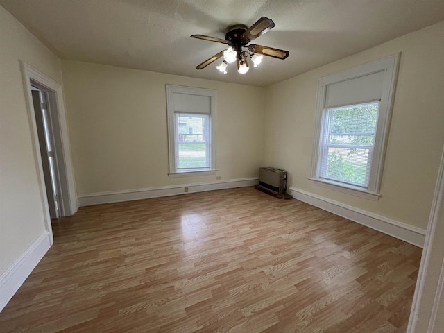 unfurnished room featuring a ceiling fan, baseboards, and light wood-type flooring