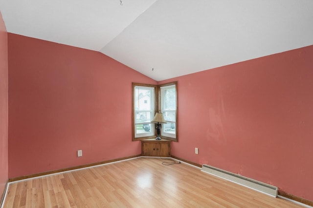 empty room with baseboards, light wood-type flooring, vaulted ceiling, and a baseboard radiator
