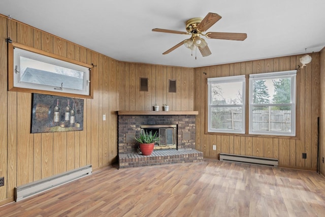 unfurnished living room with a brick fireplace, baseboard heating, and wood finished floors