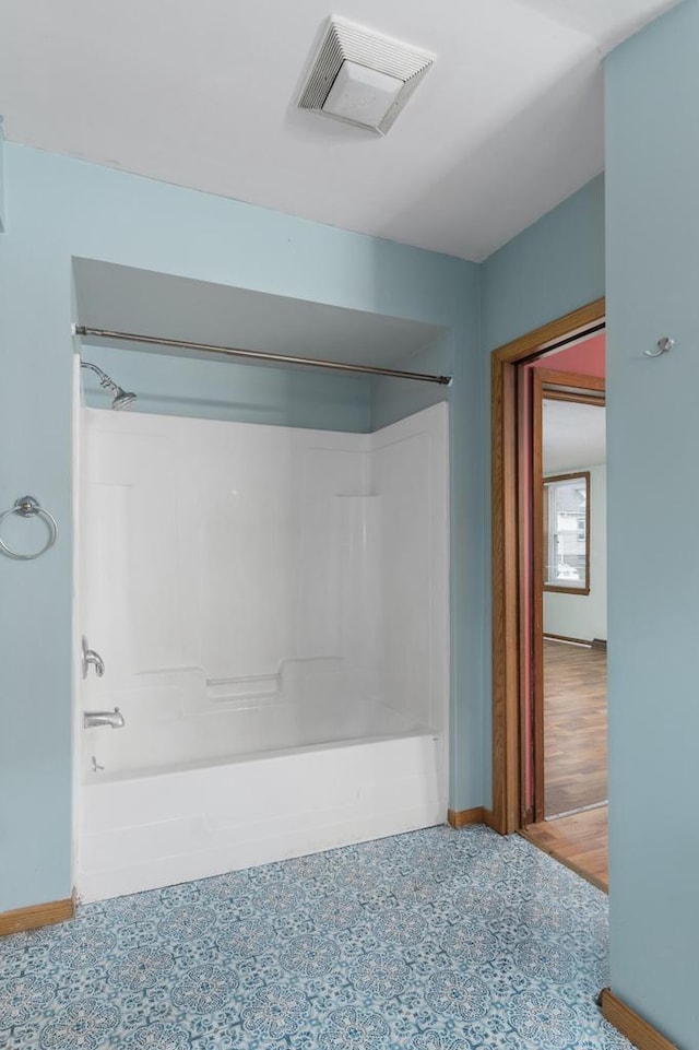 bathroom with visible vents, shower / bath combination, and baseboards