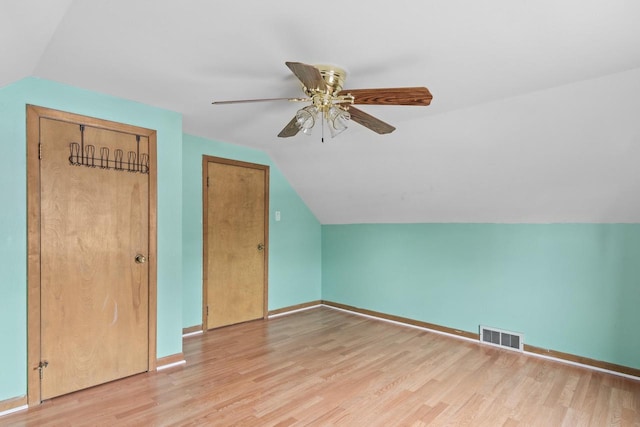 additional living space with visible vents, a ceiling fan, light wood finished floors, and lofted ceiling