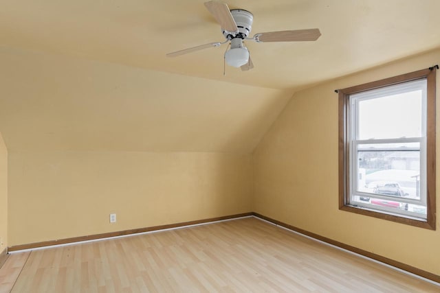 bonus room with baseboards, vaulted ceiling, and light wood-type flooring