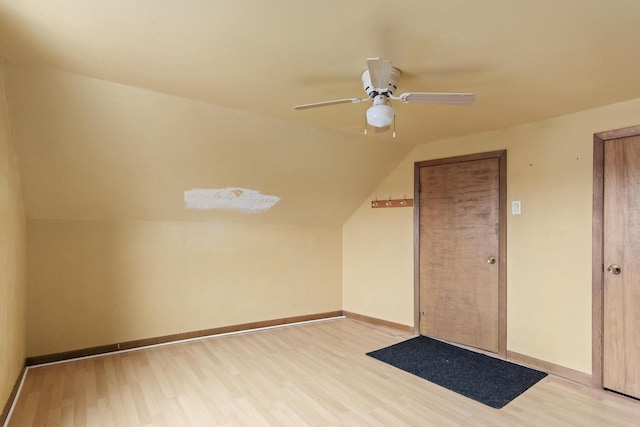 bonus room with light wood finished floors, a ceiling fan, lofted ceiling, and baseboards