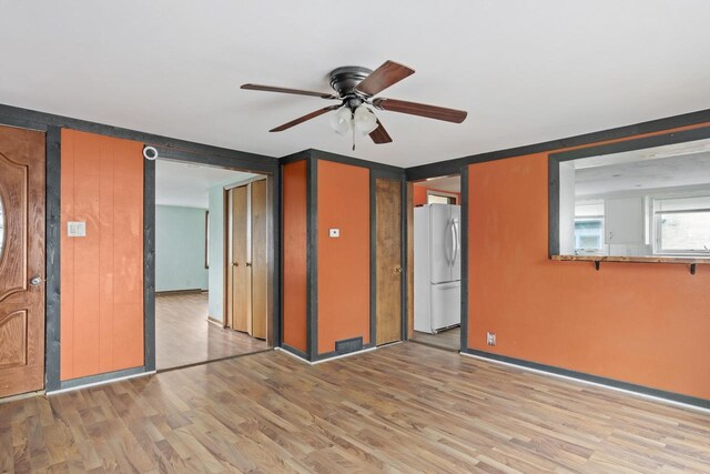unfurnished room featuring ceiling fan and light wood-style flooring