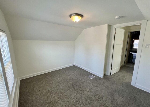4631 N 37th St, Milwaukee, WI 53209 - bonus room with baseboards, vaulted ceiling, dark carpet, and visible vents