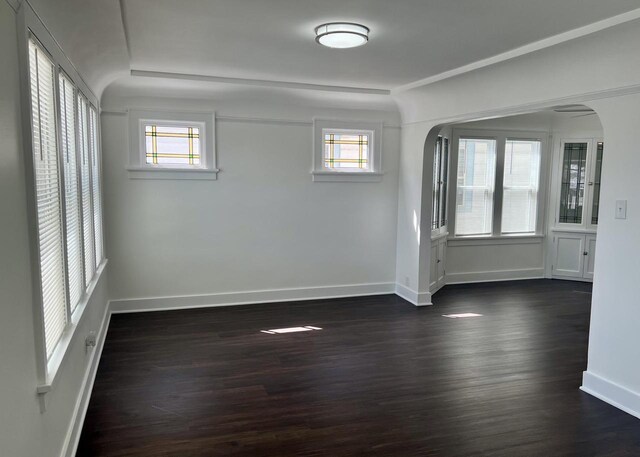 4631 N 37th St, Milwaukee, WI 53209 - spare room featuring baseboards, arched walkways, dark wood-style flooring, and a wealth of natural light