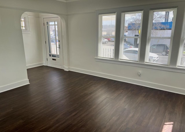 4631 N 37th St, Milwaukee, WI 53209 - empty room featuring baseboards, arched walkways, and dark wood-style flooring
