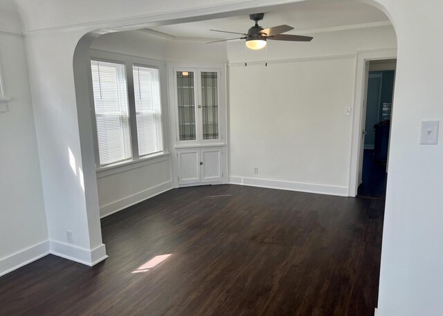 4631 N 37th St, Milwaukee, WI 53209 - spare room featuring arched walkways, baseboards, a ceiling fan, and dark wood finished floors
