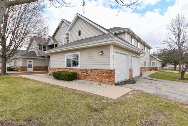 view of home's exterior featuring driveway, roof with shingles, a yard, brick siding, and a garage