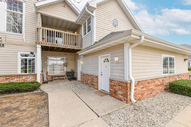 view of side of property with a balcony and brick siding