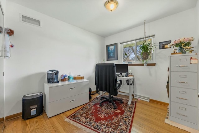 office area with visible vents, light wood-type flooring, and baseboards