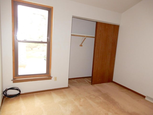 unfurnished bedroom with light carpet, baseboards, and a closet