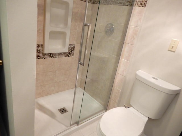bathroom with a shower stall and toilet