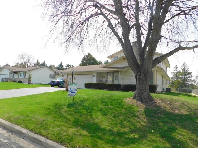 view of front of house featuring a garage, fence, concrete driveway, and a front lawn