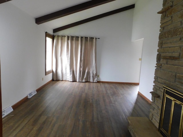 unfurnished living room with a fireplace, visible vents, vaulted ceiling with beams, and wood finished floors