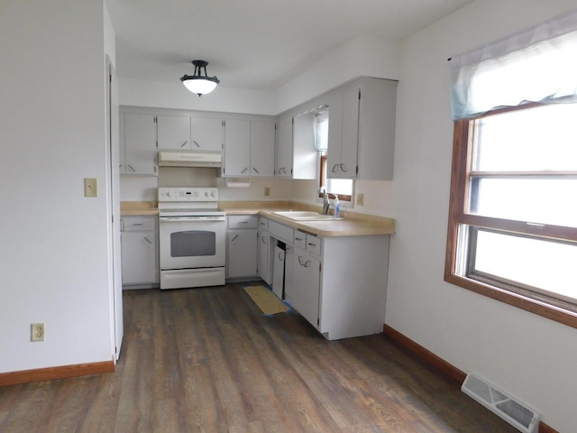 kitchen with white range with electric stovetop, a sink, light countertops, under cabinet range hood, and visible vents