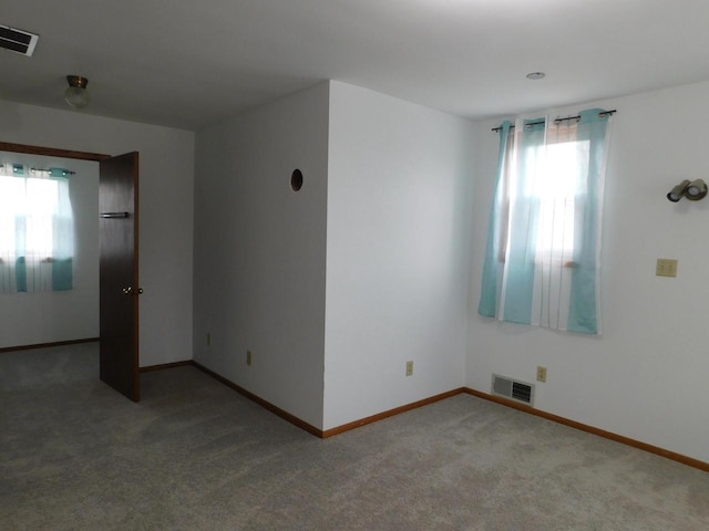 carpeted empty room with baseboards and visible vents