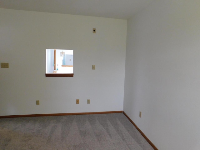 unfurnished room with baseboards and light colored carpet