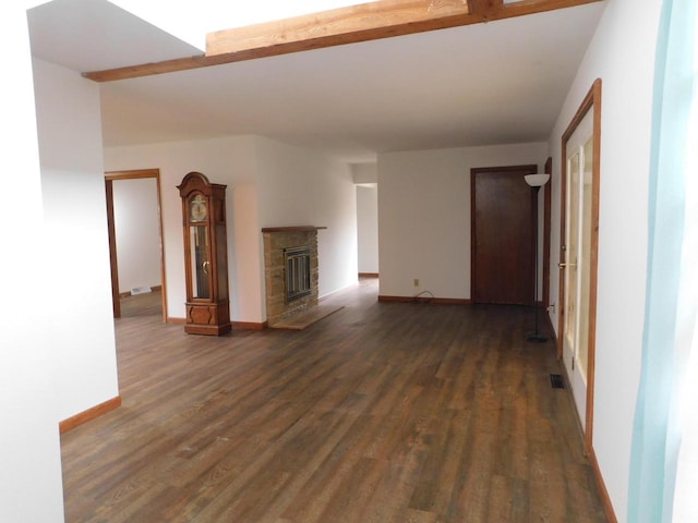 unfurnished living room featuring a fireplace, baseboards, visible vents, and dark wood-type flooring