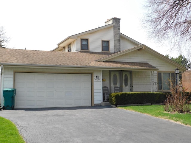 view of front of home featuring a shingled roof, an attached garage, a chimney, and driveway