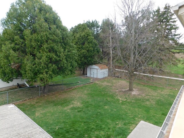 view of yard with a fenced backyard, an outdoor structure, and a shed