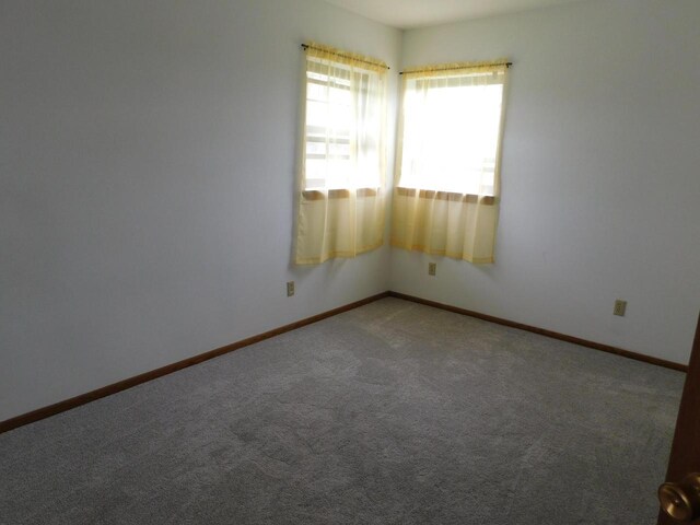 unfurnished room featuring carpet flooring and baseboards